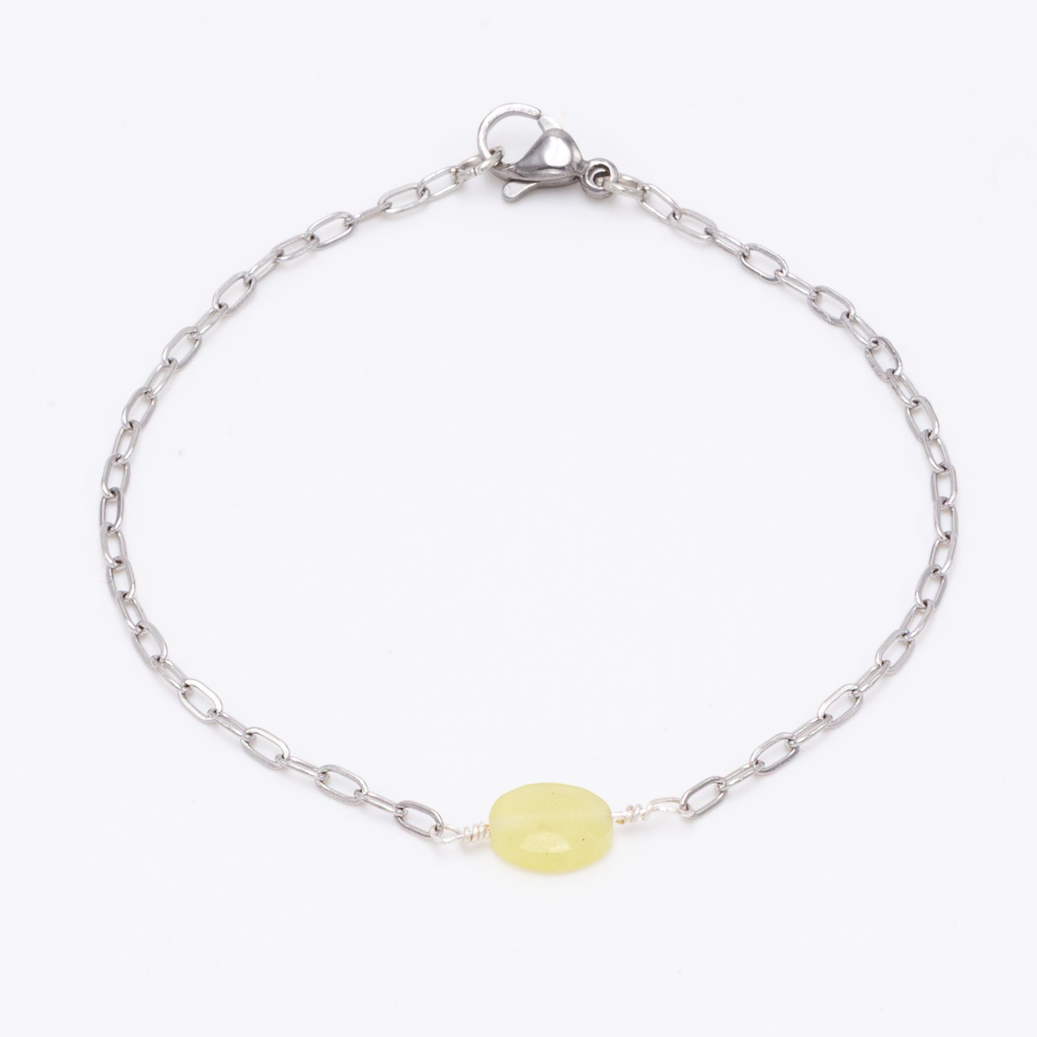 stainless steel silver bracelet with faceted 6mm yellow jasper bead with hand twists on white background